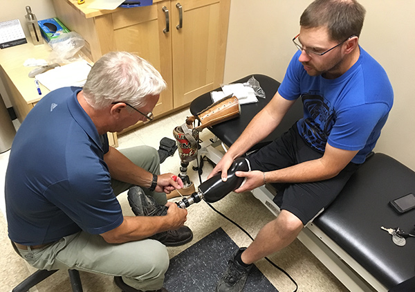 Peter helping a man after his rotationplasty surgery